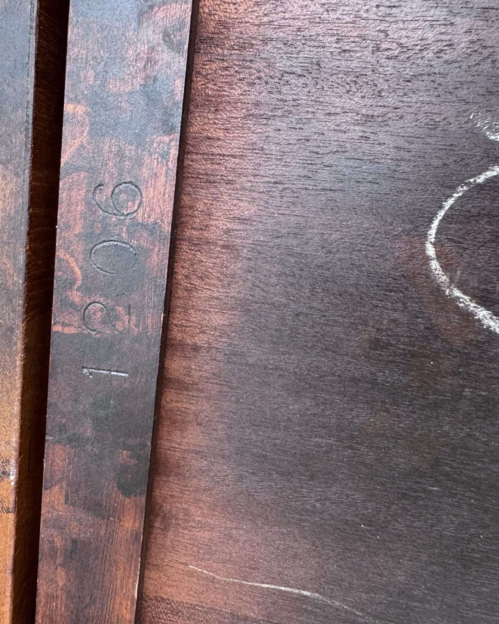 Close-up of an antique side table with a visible brand name and number.
